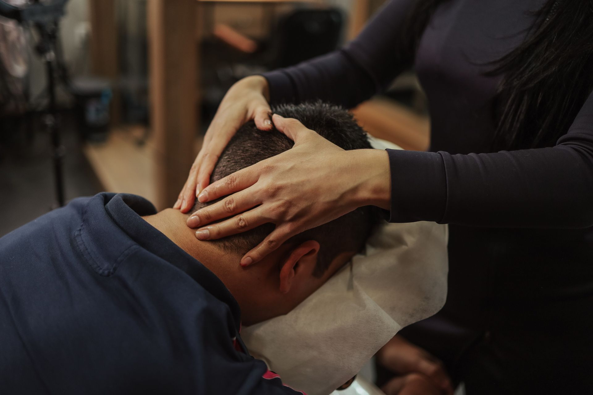 A person receiving a soothing head massage at a salon, creating a calming experience.