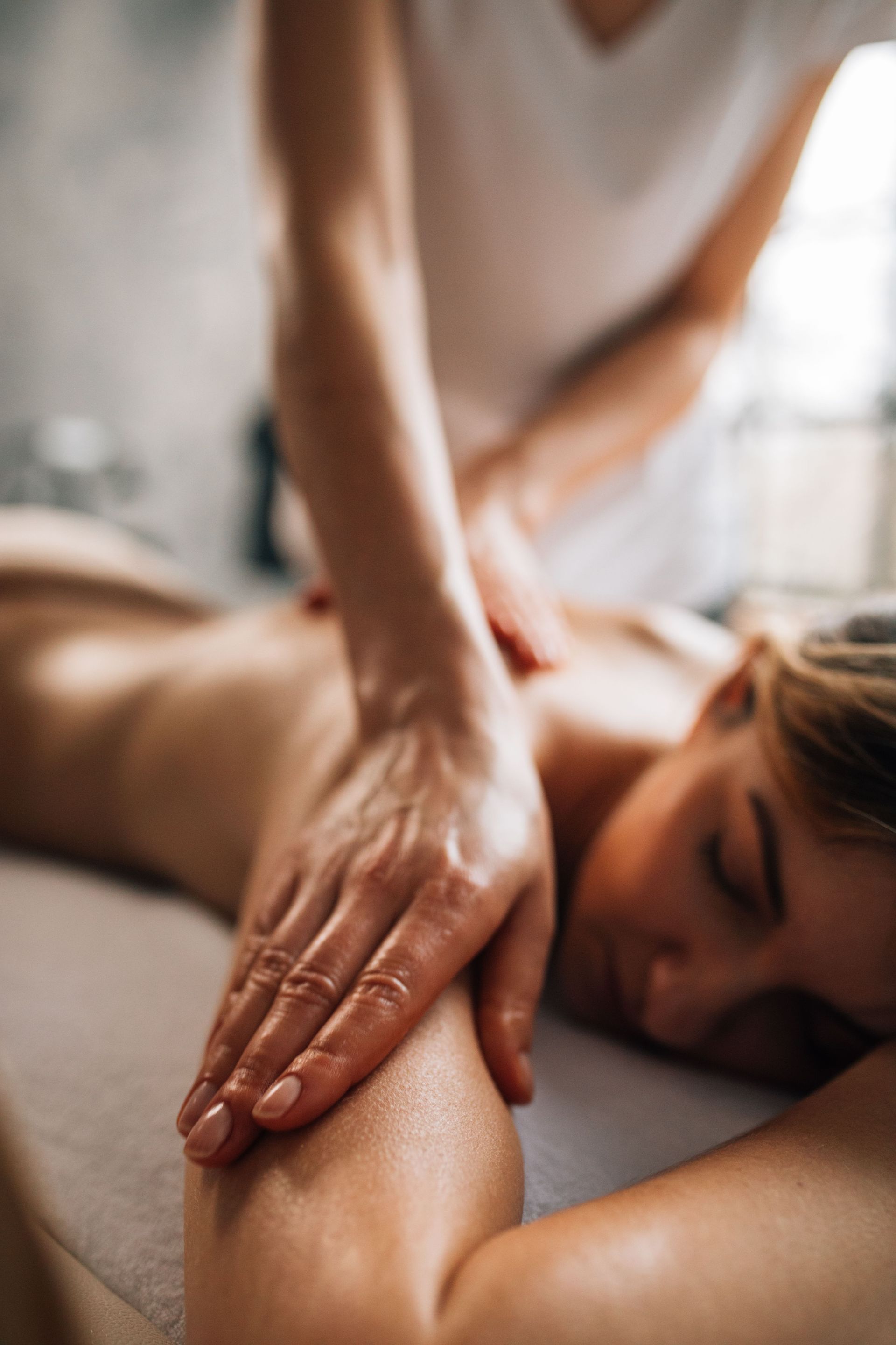 A woman enjoying a relaxing massage in a serene spa environment, promoting self-care and wellness.